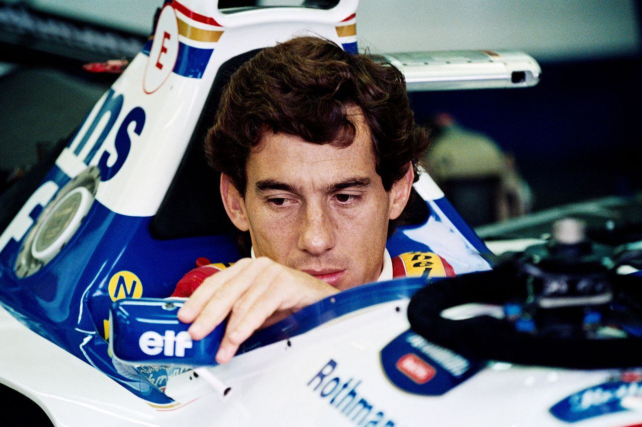 El piloto brasileño de F1 Ayrton Senna ajusta su espejo retrovisor en boxes el 1 de mayo de 1994 antes del inicio del Gran Premio de San Marino. (Foto de JEAN-LOUP GAUTREAU / AFP)