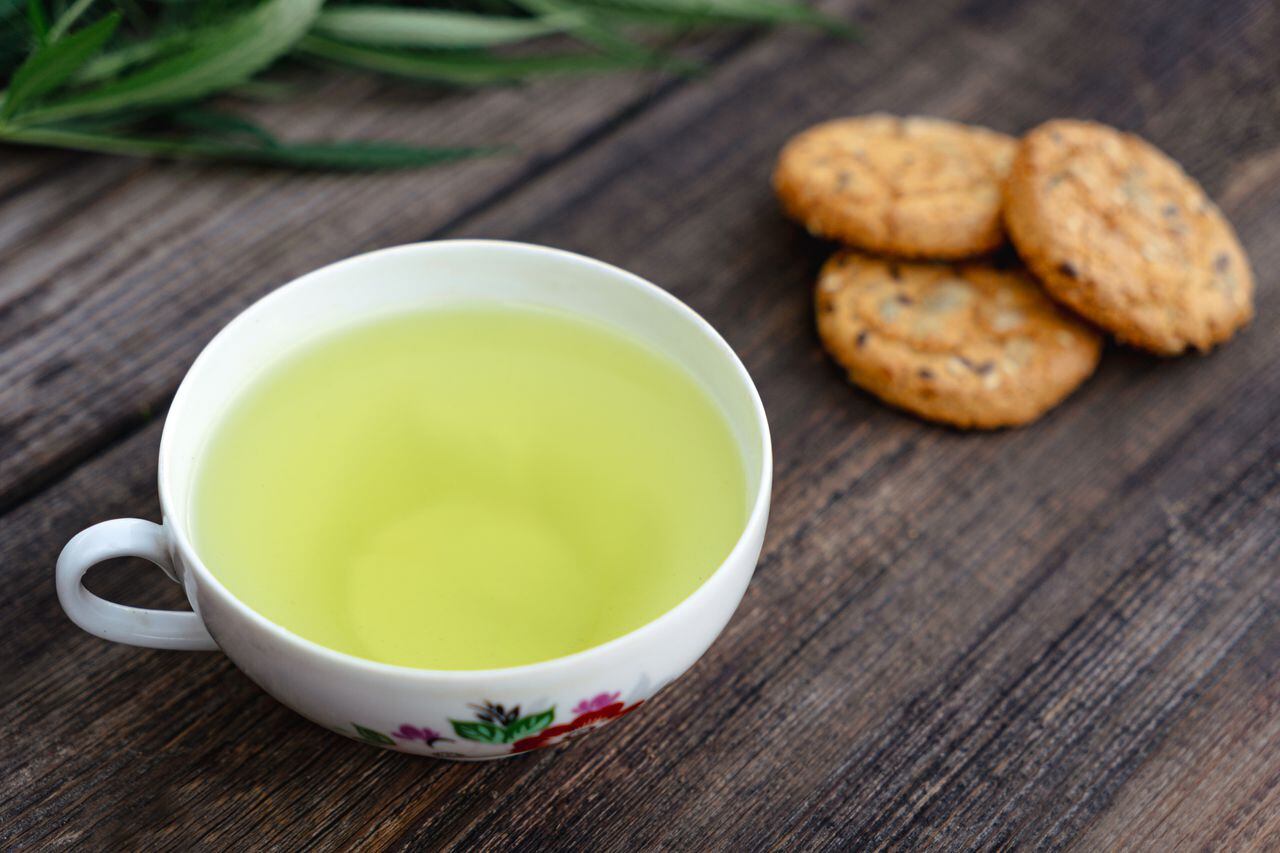 Oatmeal cookies and a mug of aromatic green tea. Vintage wooden background