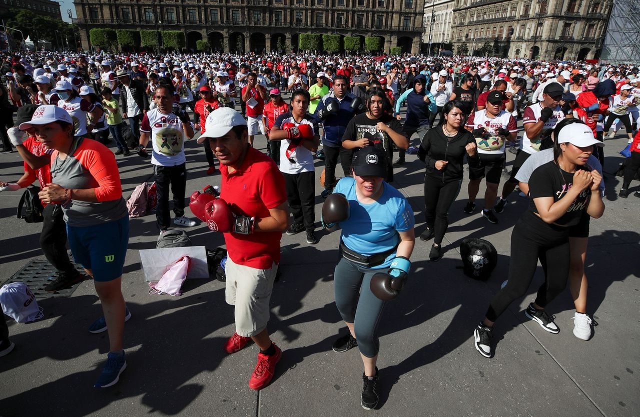 Pese a las altas temperaturas, la gente asiste a una clase de boxeo masiva en la plaza Zócalo en el centro de la Ciudad de México
