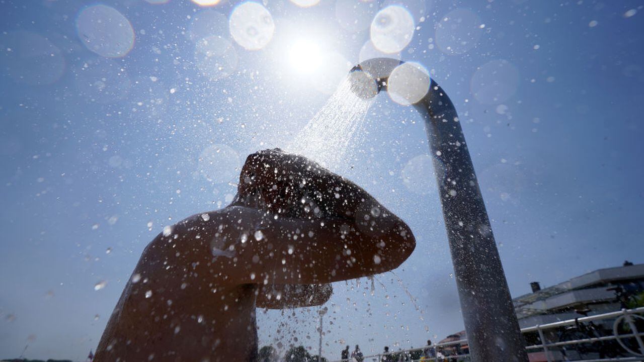 19 de julio de 2022, Schleswig-Holstein, Travemünde: Un hombre se refresca bajo una ducha en la playa del Mar Báltico en Travemünde. Foto: Marcus Brandt/dpa (Foto de Marcus Brandt/Picture Alliance vía Getty Images)
