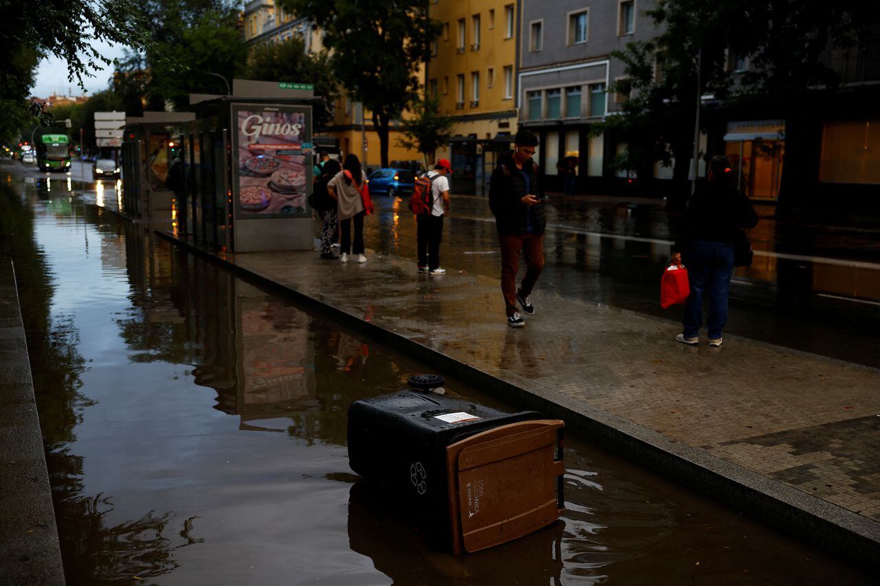 La gente espera el autobús por una carretera inundada causada por fuertes lluvias, tras una alerta roja por una tormenta severa de la Agencia Meteorológica Estatal de España (AEMET), en Madrid, España, el 4 de septiembre de 2023.