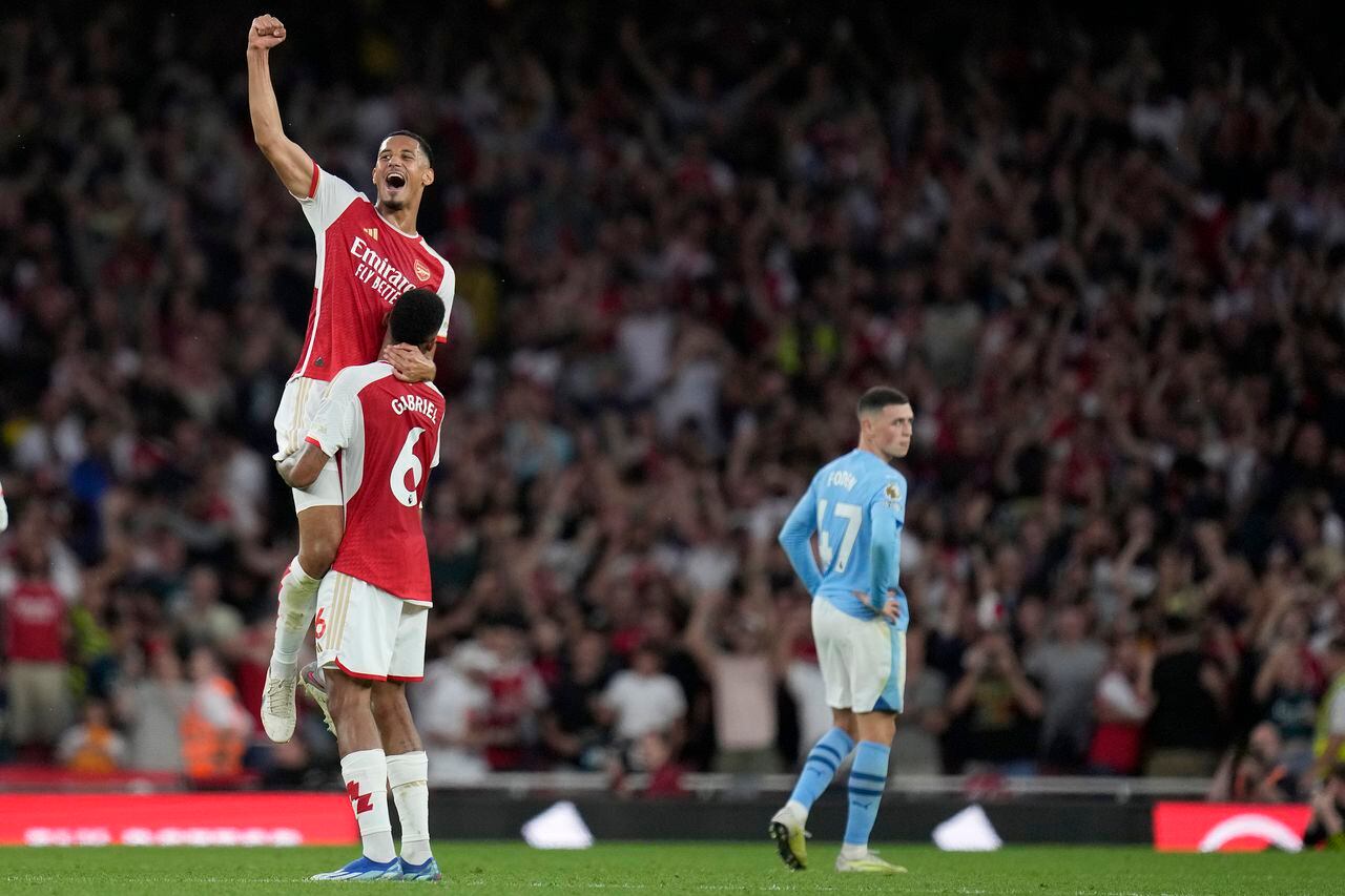 William Saliba, arriba, del Arsenal, y Gabriel del Arsenal celebran ganar el partido de fútbol de la Liga Premier inglesa entre Arsenal y Manchester City en el Emirates Stadium de Londres, el domingo 8 de octubre de 2023. (Foto AP/Kirsty Wigglesworth)