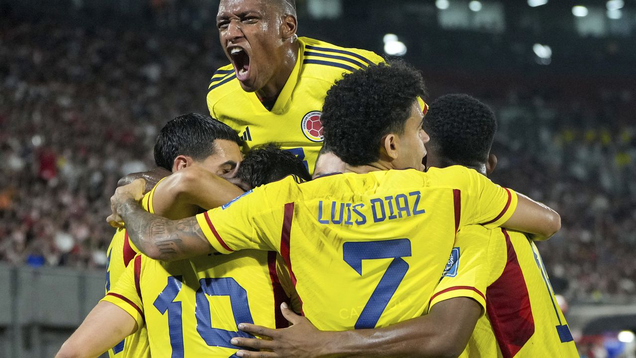 Teammates celebrate with Colombia's Rafael Santos Borre (19) after he scored his side's opening goal against Paraguay in a qualifying soccer match for the FIFA World Cup 2026 at Defensores del Chaco stadium in Asuncion, Paraguay, Tuesday, Nov. 21, 2023. (AP Photo/Jorge Saenz)