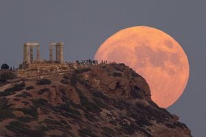 Una luna llena conocida como la 'Luna Azul' se eleva detrás del Templo de Poseidón, en el Cabo Sounion, cerca de Atenas, Grecia, el 30 de agosto de 2023.