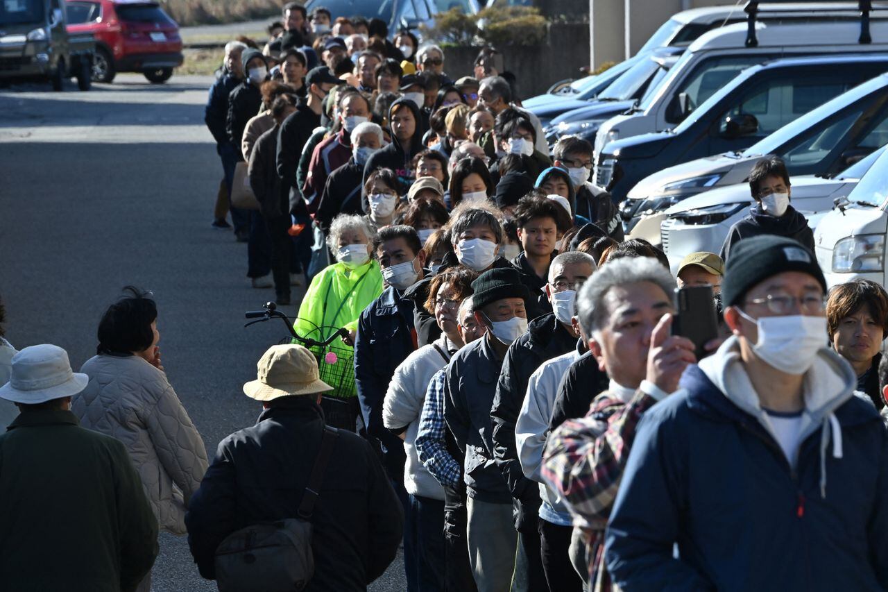 La gente hace cola alrededor del ayuntamiento de Shika mientras esperan recibir agua en un punto de distribución en Shika, prefectura de Ishikawa.
