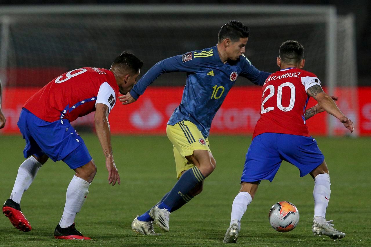James Rodríguez disputa un balón ante dos rivales chilenos en un partido por eliminatoria disputado en Santiago.