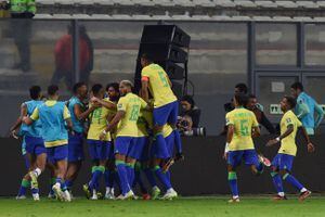 Brazilian players celebrate a goal scored by teammate defender Marquinhos (covered) during the 2026 FIFA World Cup South American qualifiers football match between Peru and Brazil, at the Nacional stadium in Lima, on September 12, 2023. (Photo by CRIS BOURONCLE / AFP)