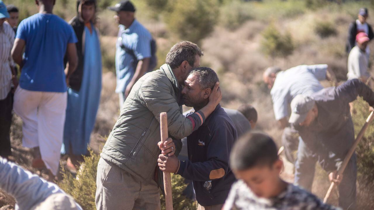 Las personas se consuelan mientras cavan tumbas para las víctimas del terremoto, en la aldea de Ouargane, cerca de Marrakech, Marruecos, el sábado 9 de septiembre de 2023.