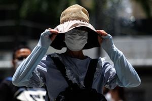 Una persona usa un sombrero y mangas largas protectoras durante una ola de calor en Hong Kong el 9 de julio de 2023.
