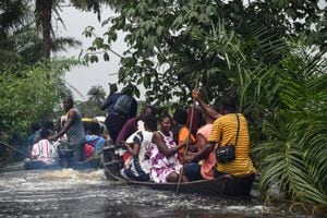 Los viajeros se movilizan en botes, mientras que los vehículos son abandonados en la carretera debido a las inundaciones.