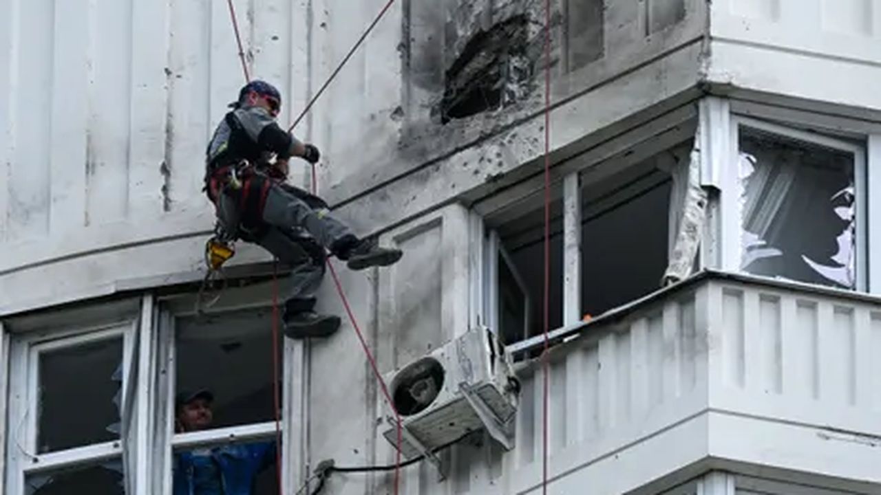 Un especialista inspecciona la fachada dañada de un edificio de apartamentos de varios pisos después de un ataque con drones en Moscú el 30 de mayo de 2023.