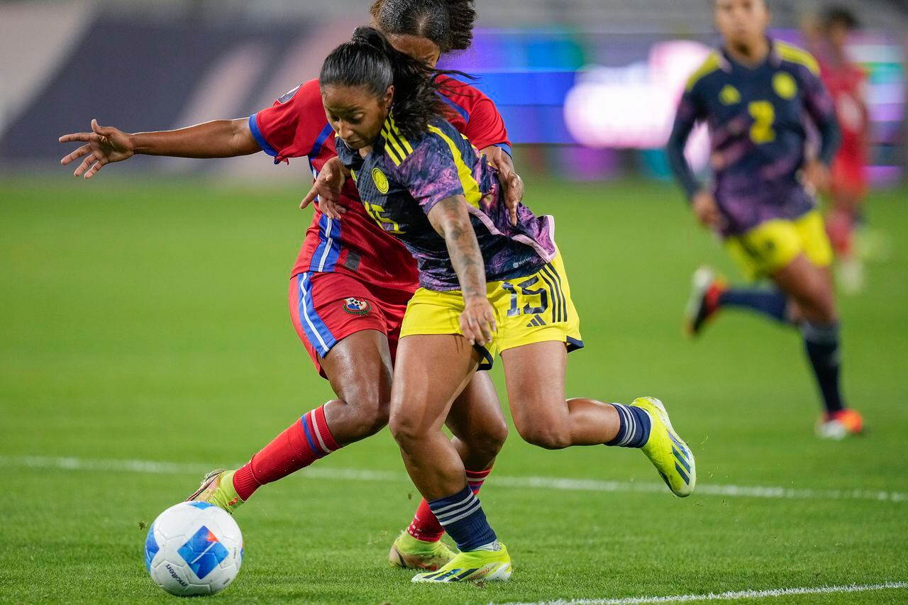 La colombiana Manuela Pavi, al frente, lucha contra Kenia Rangel de Panamá por el balón durante la segunda mitad de un partido del torneo de fútbol femenino de la Copa Oro de la CONCACAF, el miércoles 21 de febrero de 2024, en San Diego. (Foto AP/Gregory Bull)