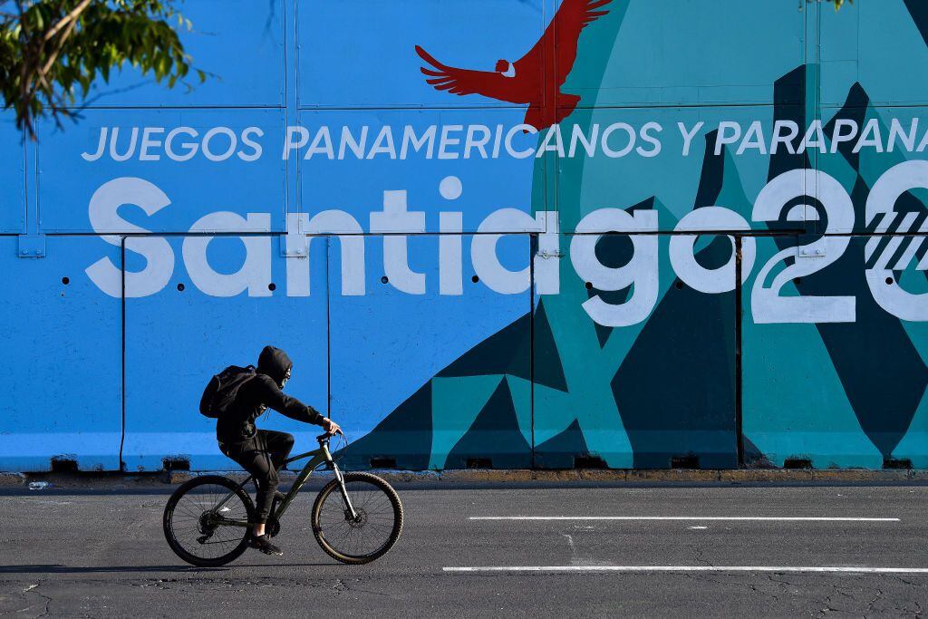 SANTIAGO, CHILE - OCTOBER 18: A cyclist passes by a mural that promotes the Pan Am Games at Baquedano Square on October 18, 2023 in Santiago, Chile. Santiago prepares to host the Pan American Games which kick off on Friday 20. The historic social unrest that paralyzed the country for months in 2019 was triggered by an increase in the subway fare and ended up in a referendum to change the the Pinochet era constitution.  (Photo by Claudio Santana/Getty Images)