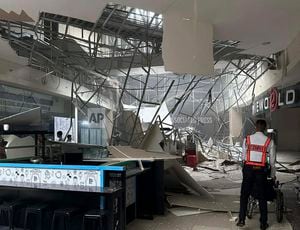 Un guardia de seguridad camina cerca del techo caído de un centro comercial tras un sismo en General Santos City, en el sur de Filipinas, el viernes 17 de noviembre de 2023. (AP Foto/Shaira Ann Sandigan)