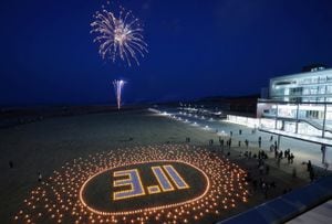 La gente mira los fuegos artificiales para conmemorar el 12º aniversario del terremoto, tsunami y desastre nuclear de 2011, en Futaba, prefectura de Fukushima, el 11 de marzo de 2023.