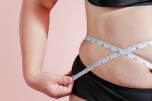 enfoque suave mida su porcentaje de grasa corporal con cinta métrica para antecedentes de grasa u obesidad