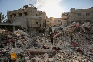 La gente busca en los edificios que fueron destruidos durante los ataques aéreos israelíes en el sur de la Franja de Gaza el 30 de octubre de 2023 en Khan Yunis, Gaza. (Foto de Ahmad Hasaballah/Getty Images)