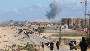 El humo se eleva tras un ataque israelí mientras los palestinos que huyen del norte de Gaza debido a la ofensiva militar de Israel se mueven hacia el sur, en medio del conflicto en curso entre Israel y Hamás, en el centro de la Franja de Gaza, el 15 de marzo de 2024.