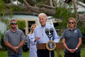 El presidente Joe Biden pronuncia un mensaje frente a una casa semidestruida por la caída de un árbol en Live Oak, Florida, el sábado 2 de septiembre de 2023, después de los estragos causados por el huracán Idalia. Atrás de Biden, su esposa Jill Biden. (AP Foto/Julio Cortez)