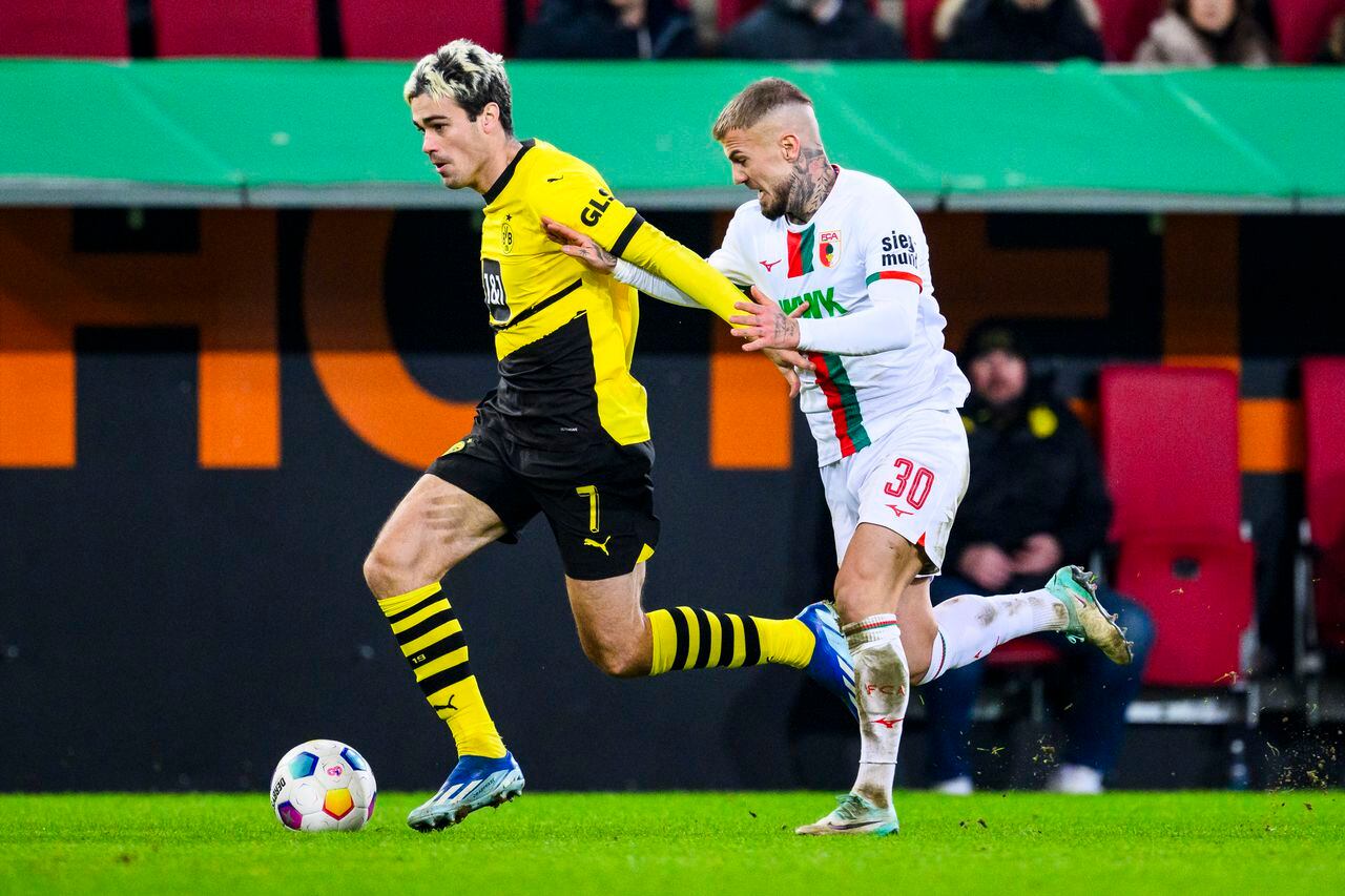 Gio Reyna del Borussia Dortmund y Niklas Dorsch del Augsburg en acción en el encuentro de la Bundesliga en Augsburg, Alemania el sábado 16 de diciembre del 2023. (Tom Weller/dpa via AP)