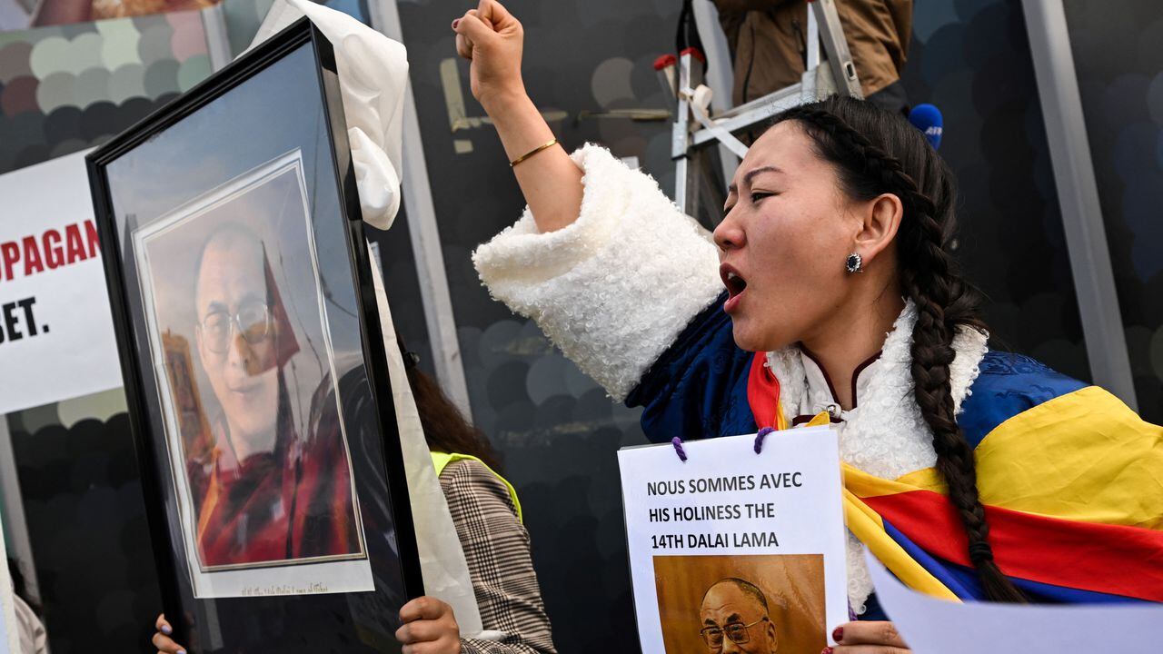 Una mujer sostiene un cartel que dice "Estamos con su santidad, el decimocuarto Dalai Lama".