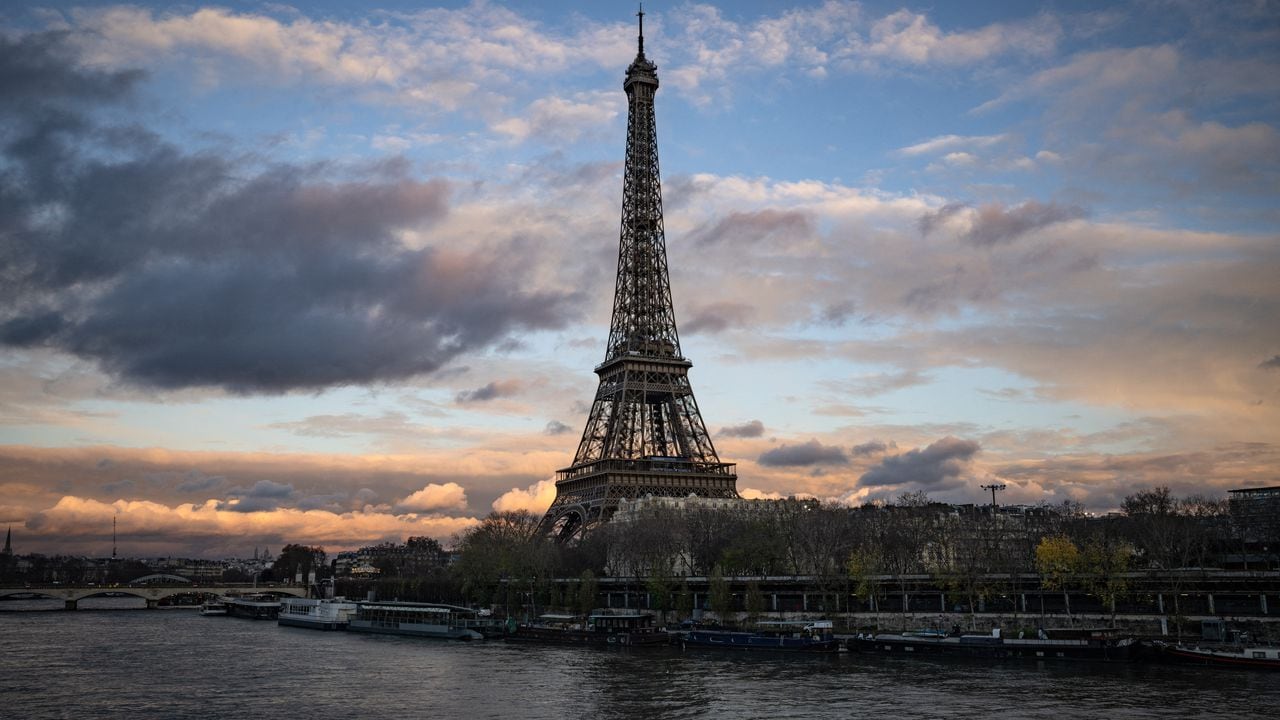 (Esta fotografía tomada el 5 de diciembre de 2023 muestra una vista general de la Torre Eiffel a lo largo del río Sena en París. Los organizadores de los Juegos Olímpicos y Paralímpicos de París (del 26 de julio al 8 de septiembre) están sudando frío por este compromiso: El éxito de las pruebas de natación en el Sena depende de la calidad de su agua, que, aunque ha mejorado, todavía no será satisfactoria en el verano de 2023. (Foto de MIGUEL MEDINA / AFP)
