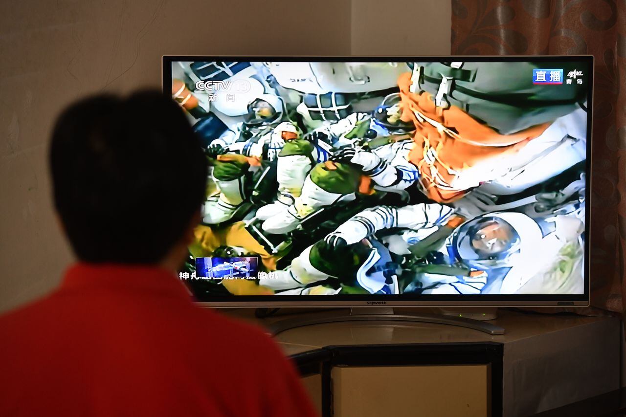 Un ciudadano ve una transmisión en vivo del lanzamiento de la nave espacial tripulada Shenzhou 16 en la ciudad de Fuyang