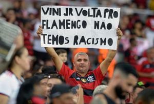 Un seguidor de Flamengo sostiene un cartel que dice "Vini Jr vuelve a Flamengo, no tenemos racismo" en apoyo del jugador brasileño Vinicius Junior durante un partido del Campeonato Brasileño 2023 entre Flamengo y Cruzeiro en el estadio Maracaná de Río de Janeiro, Brasil