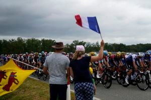 Los espectadores saludan el paso del pelotón del Tour de Francia durante la 19na etapa, el viernes 22 de julio de 2022.