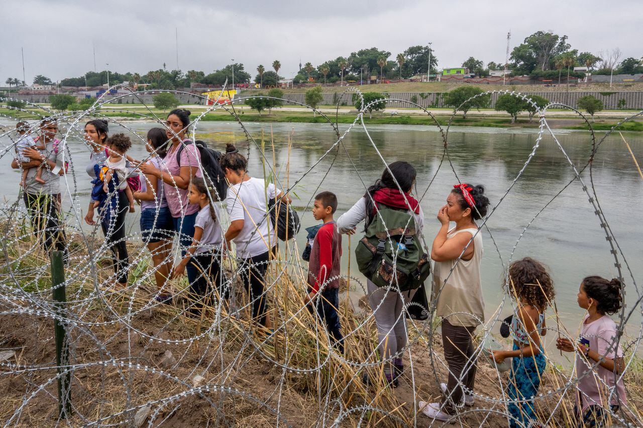 Las personas que buscan asilo hablan con las fuerzas del orden después de cruzar ilegalmente el Río Grande hacia los Estados Unidos el 14 de junio de 2023 en Eagle Pass, Texas.