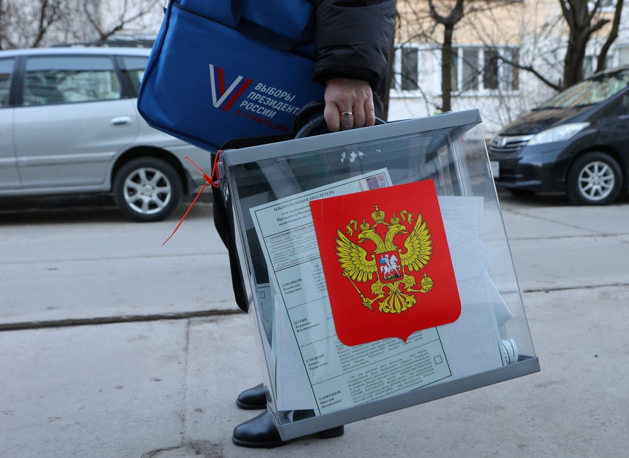 Un miembro de una comisión electoral sostiene una urna móvil durante la votación anticipada de las elecciones presidenciales de Rusia en el asentamiento de Dubovoe en la región de Belgorod, Rusia, el 11 de marzo de 2024.