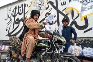 Banderas del Emirato Islámico de Afganistán, el nombre dado oficialmente al país por sus nuevos dirigentes, ondeaban en los controles de seguridad de la capital Kabul, que cayó el 15 de agosto de 2021 cuando el gobierno respaldado por Estados Unidos colapsó y sus líderes huyeron al exilio.(Photo by Wakil KOHSAR / AFP)