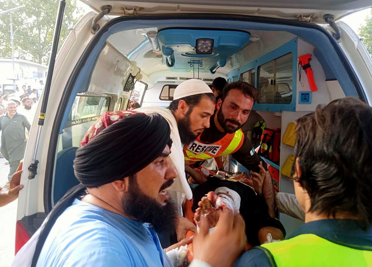 En esta foto proporcionada por Rescue 1122 Head Quarters, los rescatistas cargan a un hombre herido después de la explosión de una bomba en el distrito de Bajur de Khyber Pakhtunkhwa, Pakistán, el domingo 30 de julio de 2023.