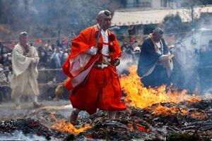 Los monjes budistas caminan descalzos sobre carbones ardientes en el festival de caminatas sobre fuego, llamado Hiwatari Matsuri en japonés, en Mt.Takao en Tokio, Japón, el 13 de marzo de 2022. Foto REUTERS/Kim Kyung Hoon