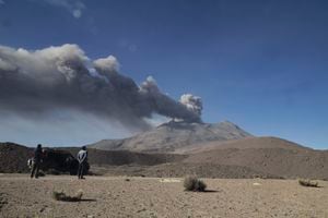 La gente observa una pila de humo y cenizas que se elevan desde el cráter del volcán Ubinas, ubicado en la región de Moquegua, en el sur de Perú, el 5 de julio de 2023.