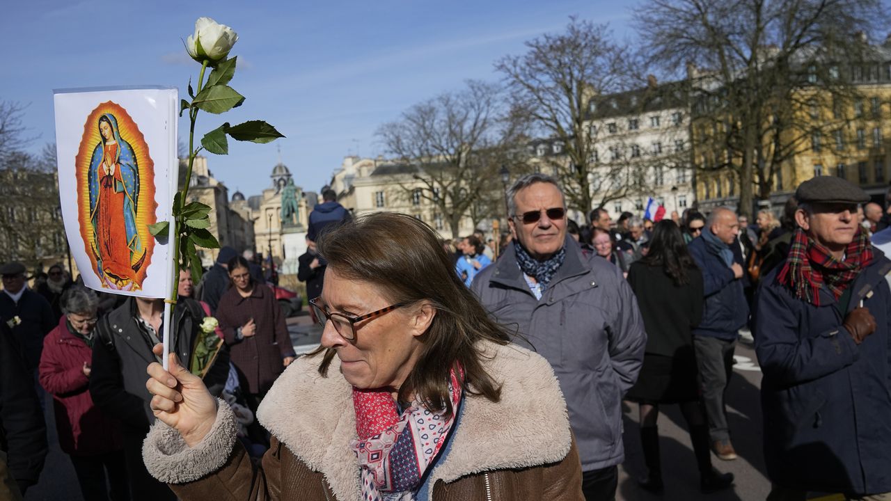Un activista antiaborto sostiene un cartel que representa a la Virgen María cerca del Palacio de Versalles durante la sesión del Congreso de ambas Cámaras del Parlamento en Versalles, al oeste de París, el lunes 4 de marzo de 2024.