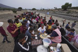 A group of nuns distribute food to migrants resting rest along the train tracks in Huehuetoca, Mexico, Friday, May 12, 2023, as they look to board a freight train heading north, the day after U.S. pandemic-related asylum restrictions called Title 42 were lifted. (AP Photo/Marco Ugarte)