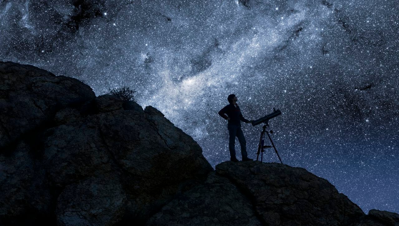 Man Stargazing in Desert