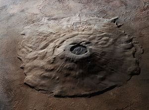 En el vasto y árido paisaje de Marte, un monumento geológico emerge de las llanuras rocosas, dominando el horizonte marciano con su presencia imponente.