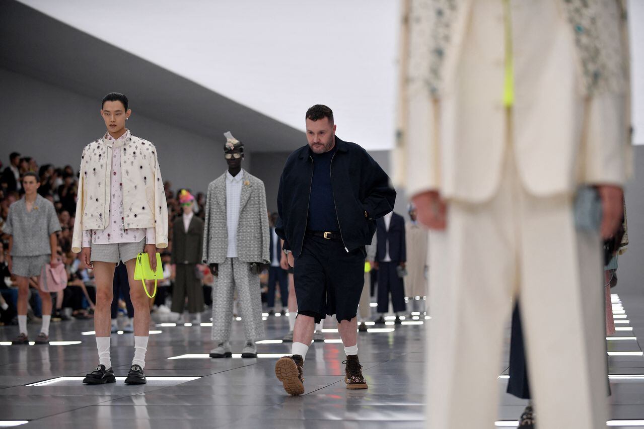 El diseñador de modas Kim Jones camina con un modelo de Dior Menswear en la Fashion Week de París. (Photo by JULIEN DE ROSA / AFP)