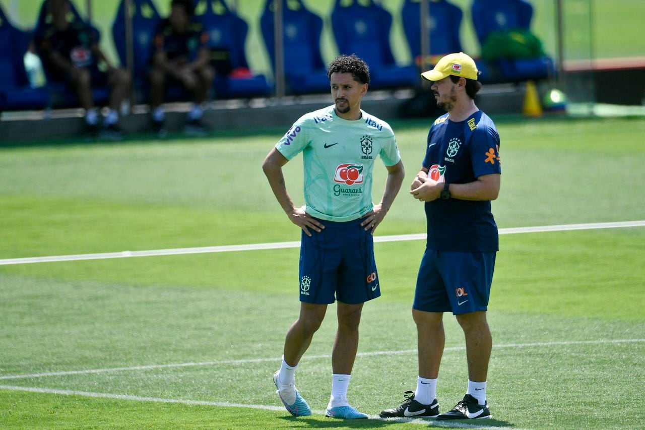 Brazil's defender Marquinhos (L) talks to coach Fernando Diniz during a training session in Teresopolis, Brazil, on November 15, 2023, ahead of the 2026 FIFA World Cup South American qualification football matches against Colombia and Argentina, on November 16 and 21 respectively. (Photo by Daniel RAMALHO / AFP)