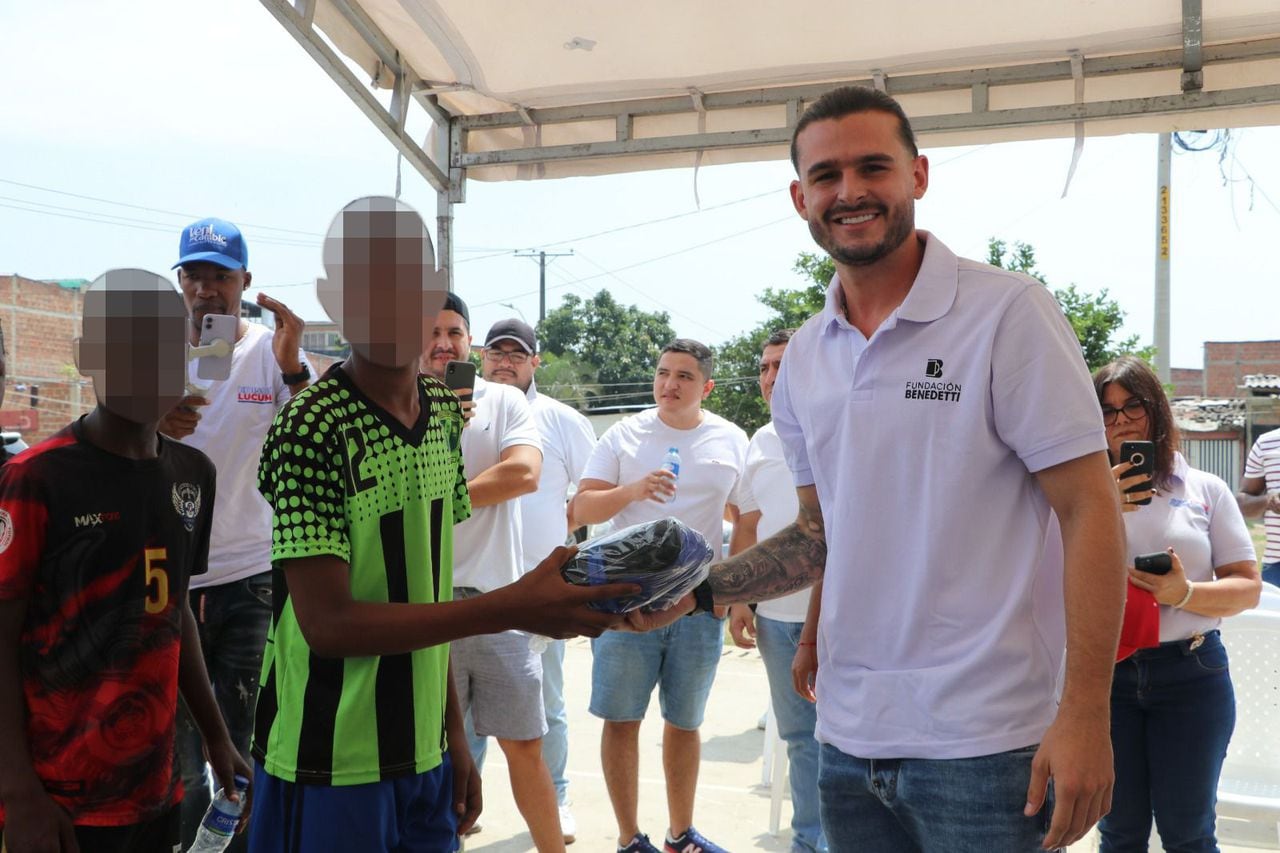 Nicolás Benedetti hace entrega de dotación a un niño de una escuela de fútbol del Distrito de Aguablanca.