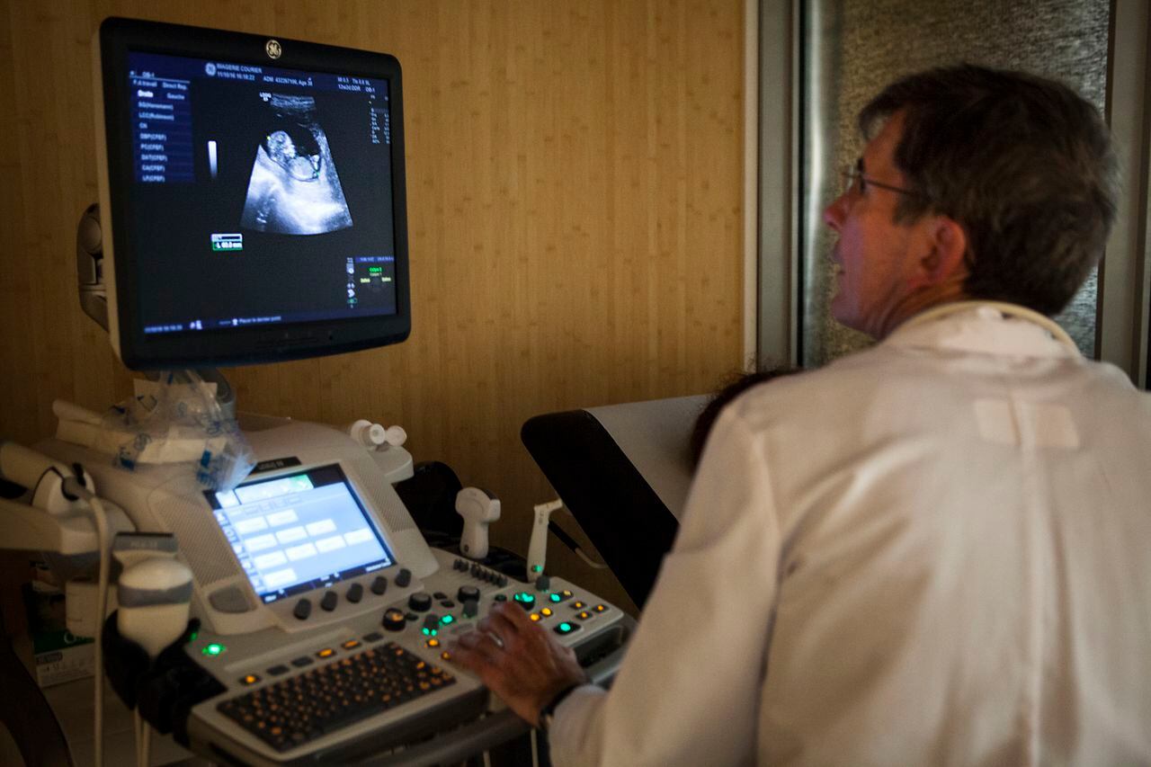 Radiólogo analiza el vientre de una mujer en embarazo. Imagen de referencia