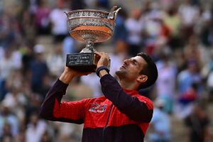 El serbio Novak Djokovic levanta su trofeo mientras celebra su victoria sobre el noruego Casper Ruud durante el partido final individual masculino del día quince del torneo de tenis Roland-Garros Open en la Court Philippe-Chatrier de París el 11 de junio de 2023. (Photo by JULIEN DE ROSA / AFP)