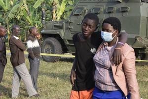 Un niño recibe consuelo en la escena de un ataque en Mpondwe, Uganda, el 17 de junio de 2023 en la Escuela Secundaria Mpondwe Lhubiriha.