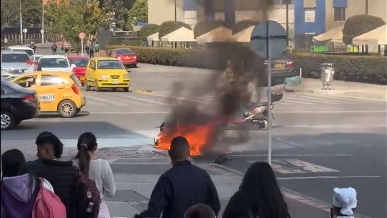 Los transeúntes observan como se incendia la moto de un delincuente en el barrio Salitre en Bogotá.