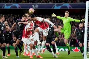 Bayern's Leon Goretzka, left, and Arsenal's William Saliba, right, challenge for the ball in front of Bayern's goalkeeper Manuel Neuer during the Champions League quarter final first leg soccer match between Arsenal and Bayern Munich at the Emirates Stadium, London, Tuesday, April 9, 2024. (AP Photo/Frank Augstein)