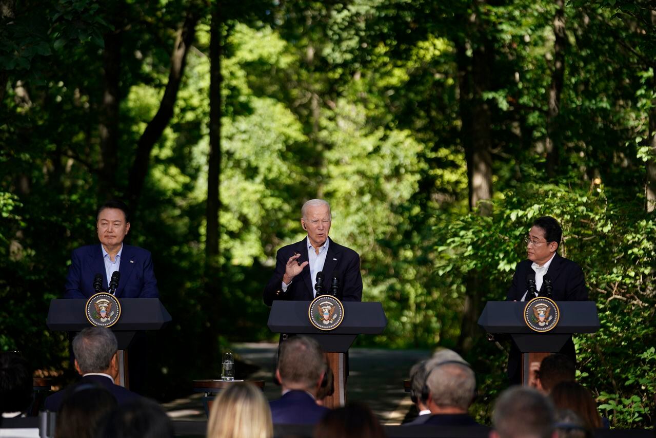 El presidente de Corea del Sur, Yoon Suk Yeol, a la izquierda, y el primer ministro de Japón, Fumio Kishida, a la derecha, escuchan mientras el presidente Joe Biden habla durante una conferencia de prensa el viernes 18 de agosto de 2023 en Camp David