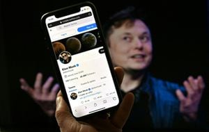 En esta ilustración fotográfica, la pantalla de un teléfono muestra la cuenta de Twitter de Elon Musk con una foto de él de fondo, el 14 de abril de 2022, en Washington, DC.