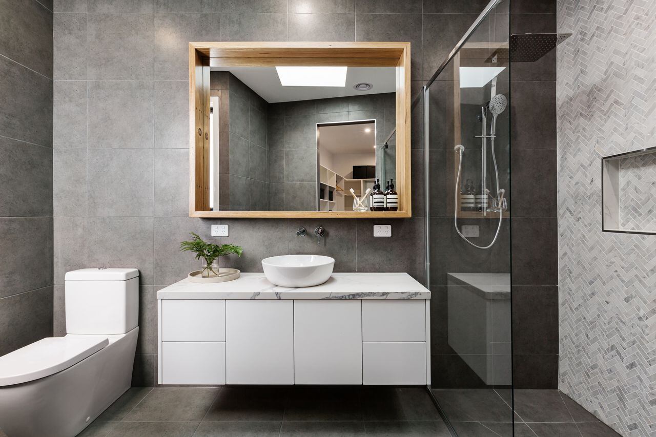 Baño moderno de diseño gris con azulejos de ducha en espiga